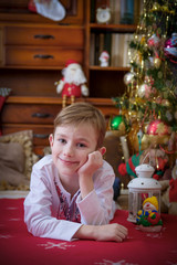 Boy lying under Christmas tree