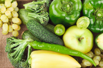Set of green fresh raw vegetables and fruits on the burlap