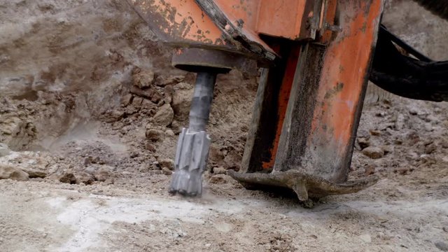 Rock driller start drilling the ground close up slowmo