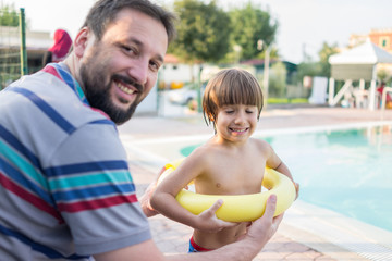 Obraz na płótnie Canvas Young boy kid child splashing in swimming pool having fun leisur