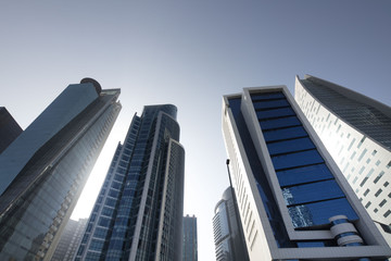 Naklejka premium Buildings in perspective. Wide angle shot from bellow. Blue sky. Modern architecture.