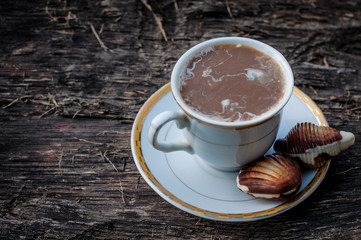 A cup of coffee with milk on a wooden background