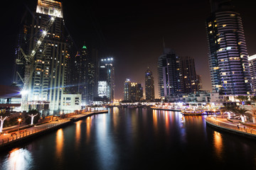 Architecture theme. Dubai marina. Luxurious travel and living, business and finance theme. Luxurious apartments. High value property. Night lights. Illuminated skyline. Big construction site.