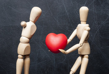 Concept protection of handicapped people. Wooden figure of healthy man gives another physically...