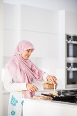 Muslim Arabic traditional woman in kitchen preparing food for lu