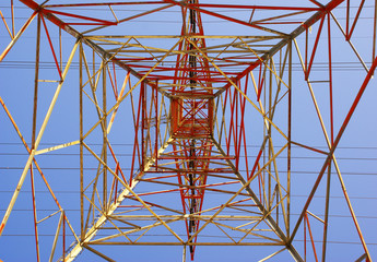 Electrical tower glowing in sunset colors seen from directly und