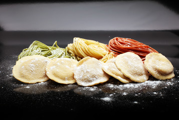 Fettuccine and spaghetti with ingredients for cooking pasta on a white background, top view. Flat lay