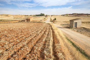 landscape with a plowed land and a country road in Cuencabuena, Teruel, Spain