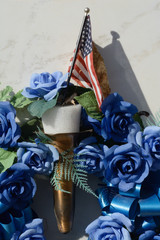 Close up of Memorial wreath and American flag left on mausoleum wall  