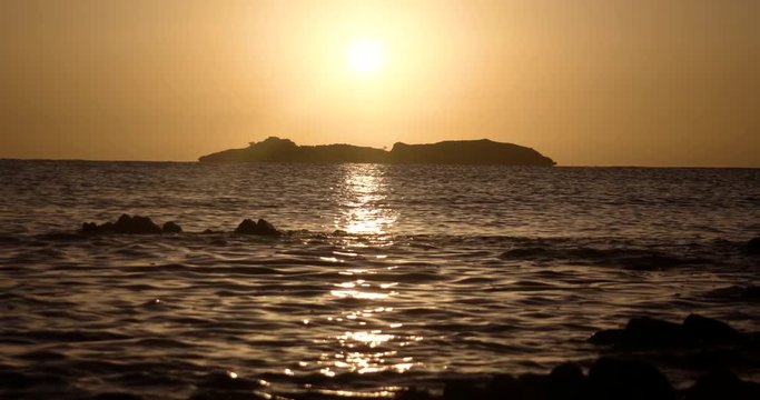 Beautiful Sunrise View at the Sea With Silhouette of an Island on the Horizon