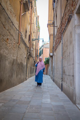Muslim traditional woman visiting old city Venice in Italy