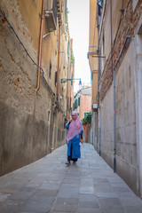 Muslim traditional woman visiting old city Venice in Italy