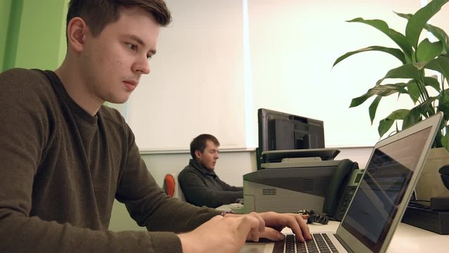 Male Office Worker Typing on Computer