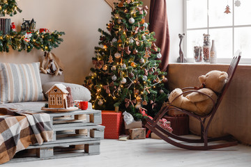 Calm image of interior modern home living room decorated christmas tree and gifts, sofa, table covered with blanket.