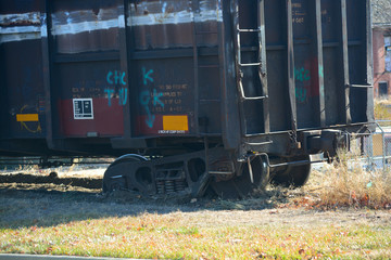 Fototapeta na wymiar Derailed Train Car Off The Tracks Stuck In The Dirt
