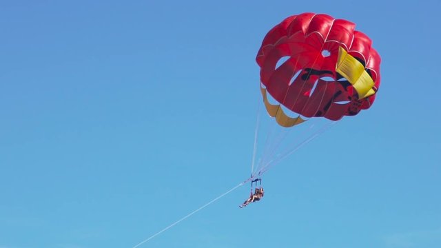 Excited tourists parasailing high in the sky, extreme sport, summer activities