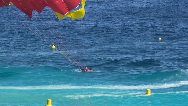People with parachute landing in sea, parasailing, extreme sport, active life