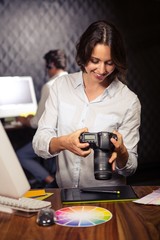 Creative businesswoman looking at pictures on camera