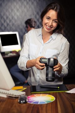 Creative businesswoman looking at pictures on camera