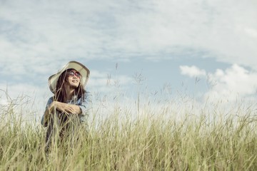 Sad young girl sitting alone on a grass outdoors,Sadness. Loneli