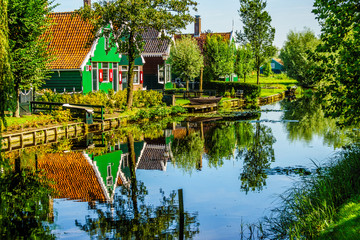 Traditional Houses reflecting in the Canal in the Historic Village of Zaanse Schans on the Zaan River in the Netherlands