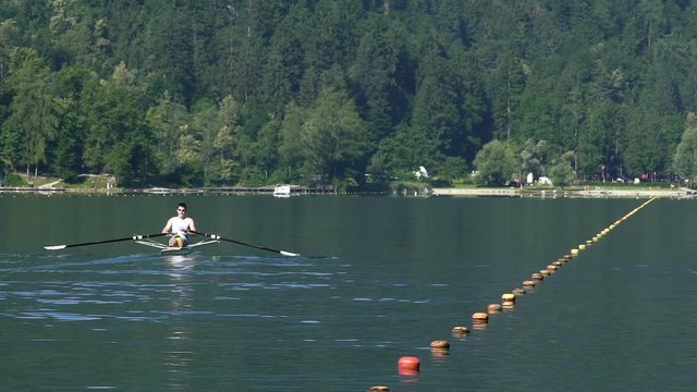 Strong male training in rowing on lake, healthy lifestyle, professional sport