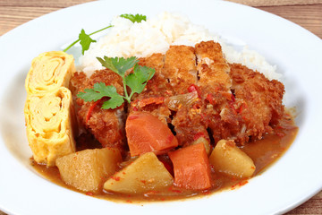 Close up rice with fried pork,omelet roll,yellow curry .