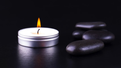 Obraz na płótnie Canvas Close-up of black stones and candle