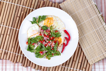 Thai food,Spicy wing bean with pork topped fried egg.