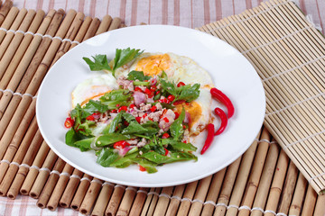 Thai food,Spicy wing bean with pork topped fried egg.