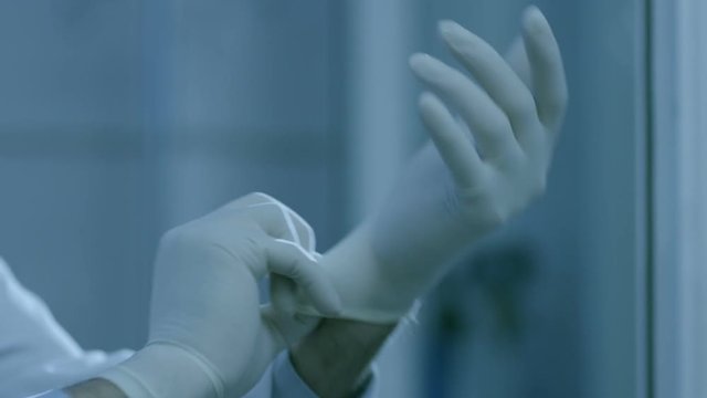 Doctor wearing with glove in hospital. Medical gloves. Healthcare worker putting on medical gloves.