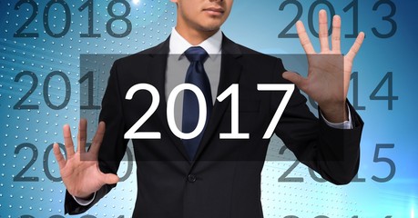 Business man in digitally generated background touching 2017