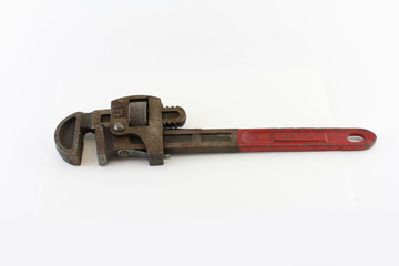 Old red handled pipe wrench isolated on white
