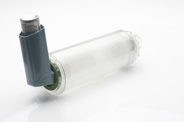 Asthma inhaler with spacer on white background