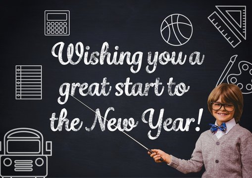 Smiling boy pointing at blackboard with new year greeting quotes