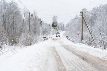 Vanishing snow-covered dirt road with lorry on bridge. Novgorodsky region, Russia 

