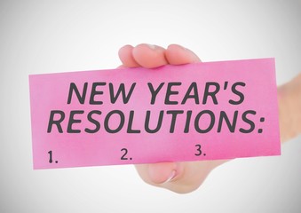 Hand holding a card with new year resolution goals