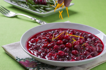Sprinkling Orange Zest over Bowl of Cranberry Sauce