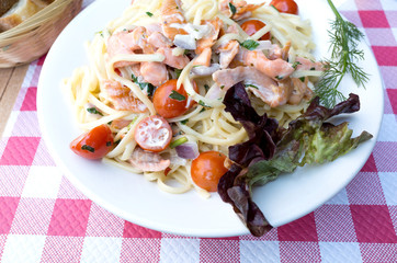 close-up of plate of pasta and smoked salmon with tomato