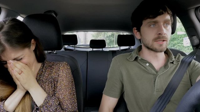 Woman crying while boyfriend is angry driving car.