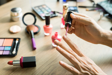 Obraz na płótnie Canvas Girl doing nail pianting on dressing table and cosmetics