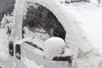 Fragment of car, covered with snow during snowfall