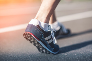 Runner feet on track closeup focus on sport shoe. Getting ready to start. Urban Jogger running