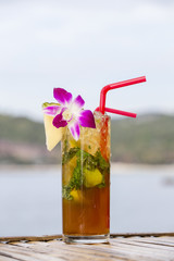 Refreshing drink with lime, mint and pineapple on a tropical beach