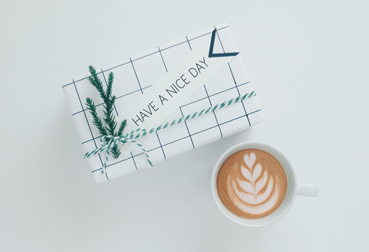 Gitf box with text Have a nice day card near glass of coffee