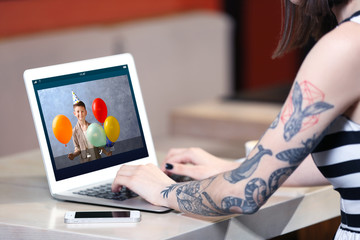 Woman talking to son via online video chat during birthday party