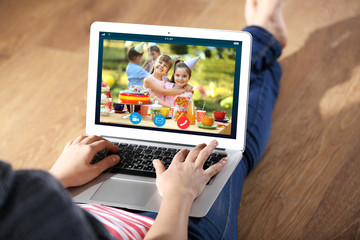 Fototapeta na wymiar Woman talking to daughter via online video chat during birthday party