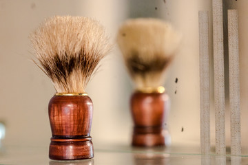 Old brown vintage shaving brush reflects in mirror