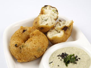 methu vadai with coconut chutney served in a dip plate on white