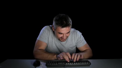 Man excitedly looking at a computer monitor. Dark studio